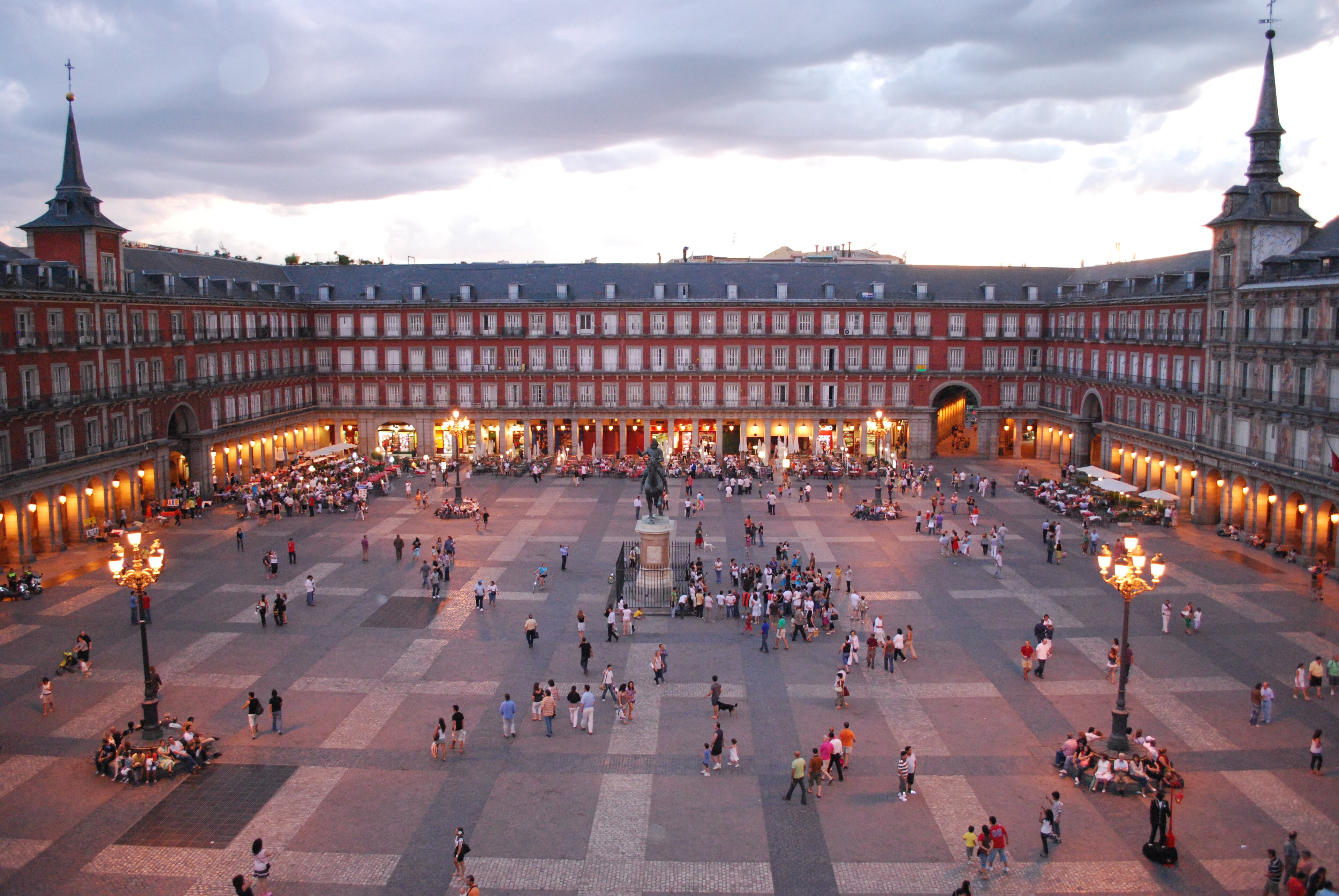 Plaza Mayor de Madrid al atardecer, con gente en la plaza y luces encendidas